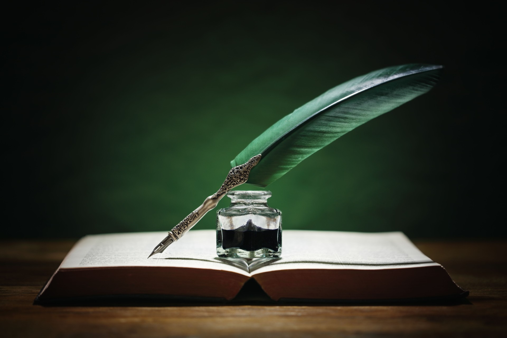 Quill pen and inkwell on old book